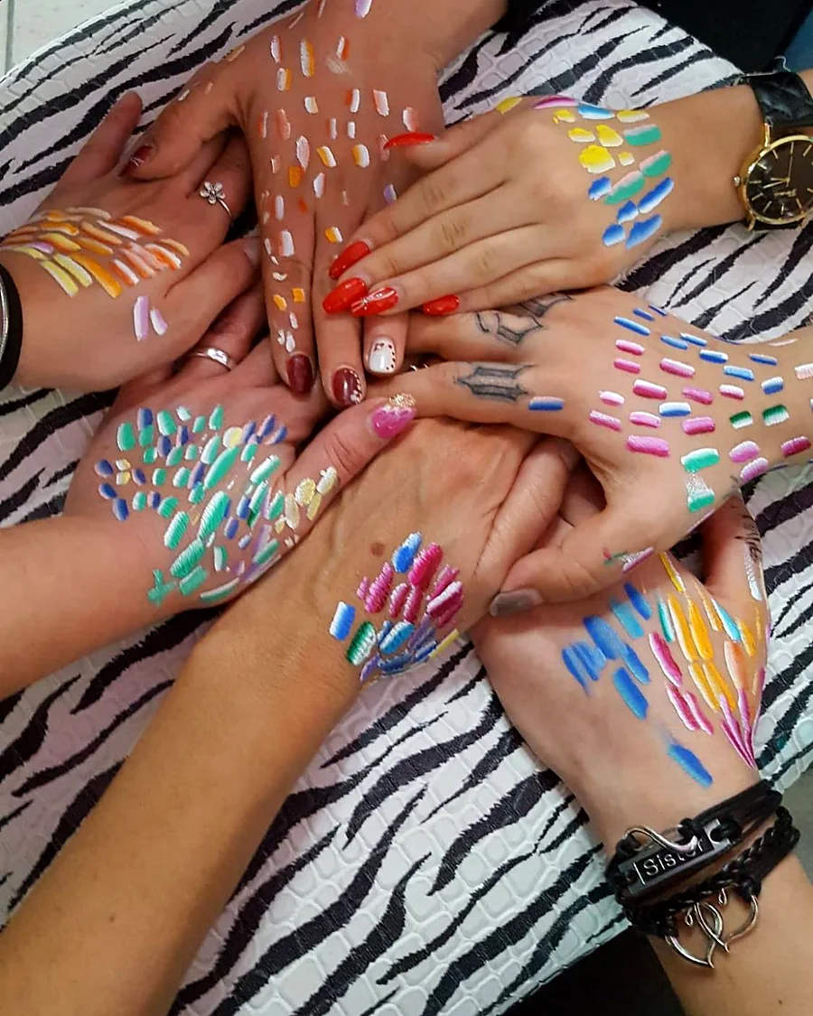 Le mani delle allieve con le prove di colore a pennello, durante un corso dell'Academy